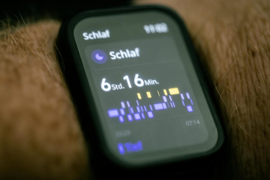 Close-up of a smartwatch displaying sleep tracking data in German.